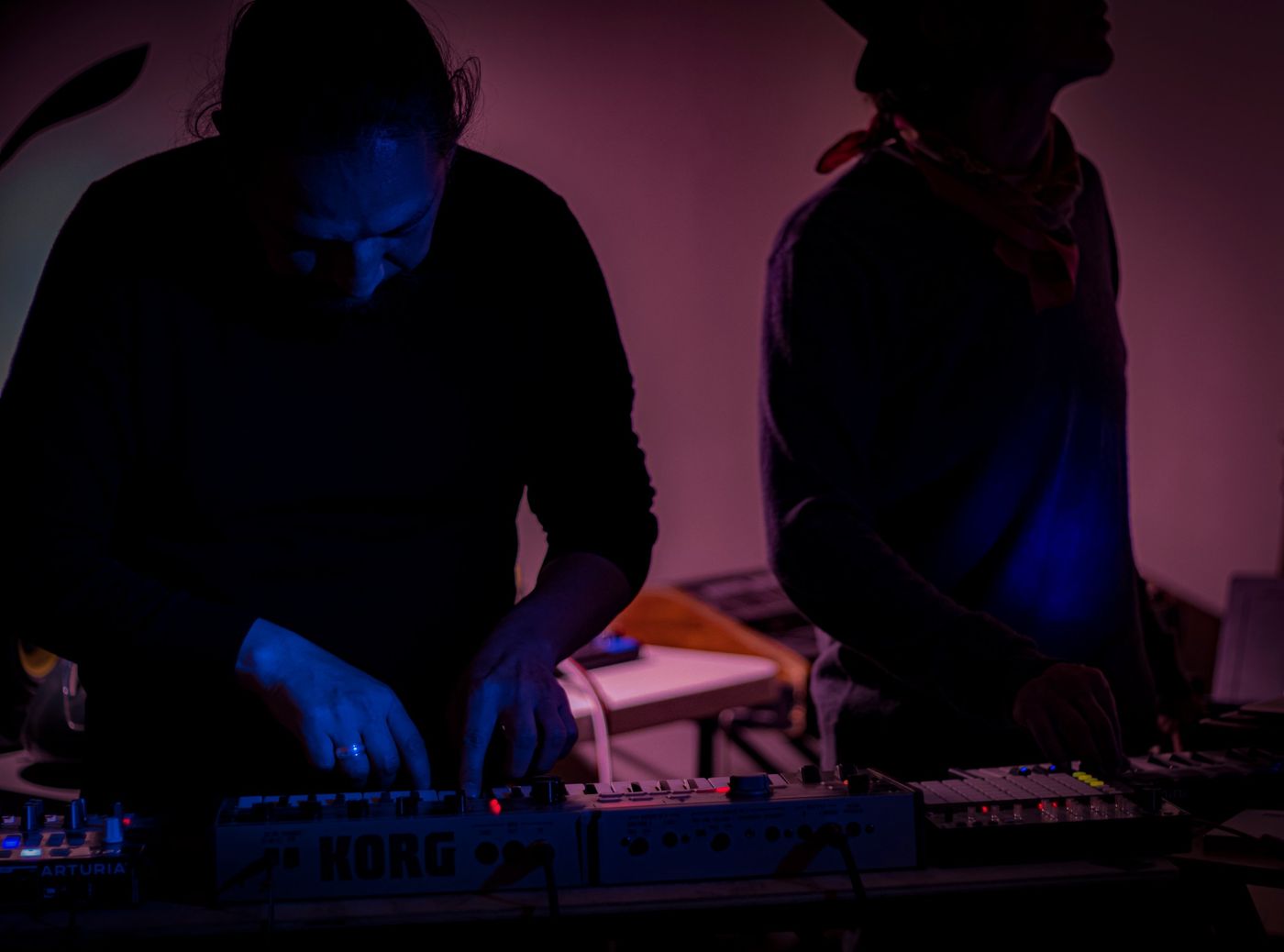 Siluetas tocando sintetizadores Korg y Arturia